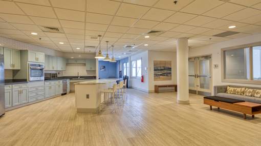 A spacious kitchen and living room with wooden floors and modern appliances.