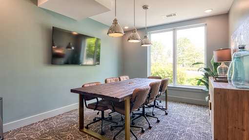 A conference room with a long table and chairs.