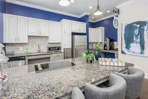 A kitchen with granite countertops and white cabinets.
