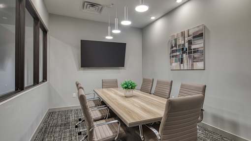 A conference room with a long table and chairs.