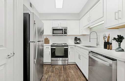A modern kitchen with stainless steel appliances and white cabinets.