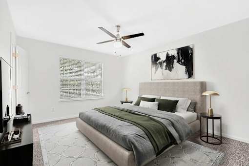 A bedroom with a large bed and a ceiling fan.