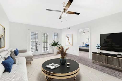 A living room with a ceiling fan and a coffee table.