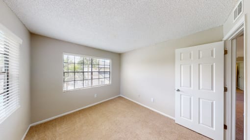 a bedroom with a large window and a white door