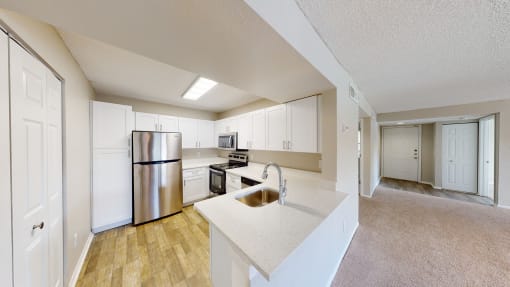 a kitchen with white cabinets and stainless steel appliances