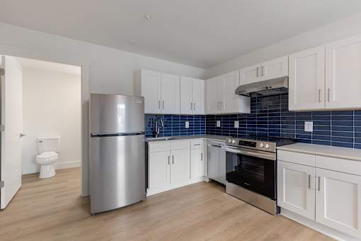A kitchen with a stainless steel refrigerator, oven, and cabinets.