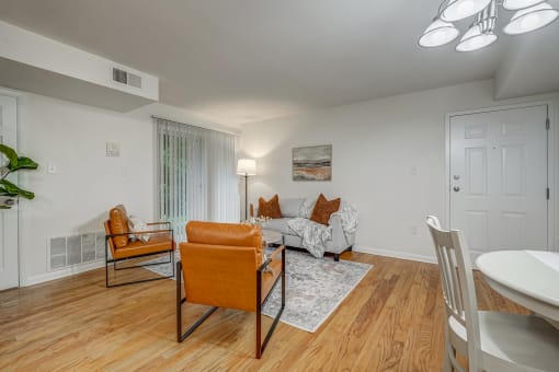 a living room with a couch and chairs and a dining table