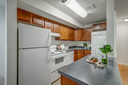 an updated kitchen with white appliances and wood cabinets