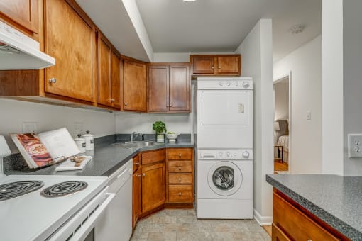 a kitchen with a washing machine and a dishwasher and wooden cabinets