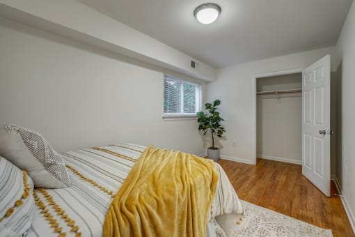 a bedroom with a bed and a yellow blanket