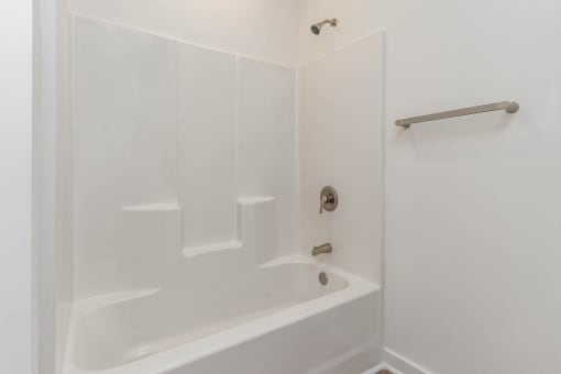 a white bathroom with a shower and a tub