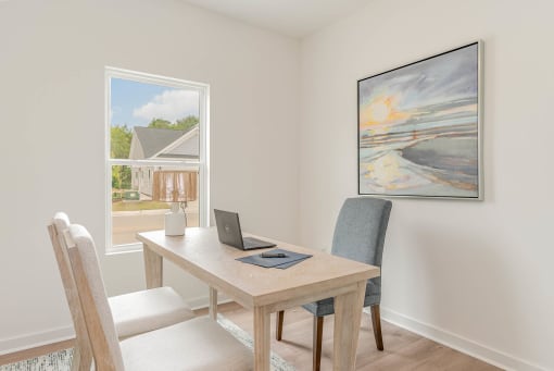 a dining room with a table with a laptop on it
