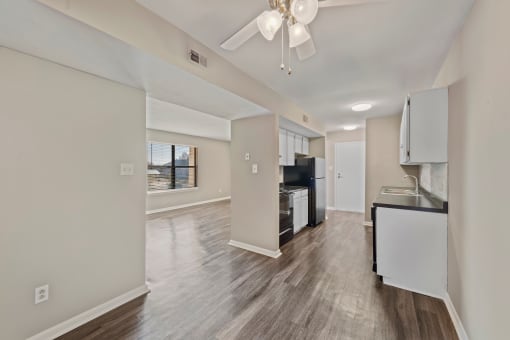 a kitchen and living room with a ceiling fan