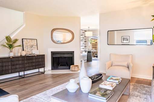 A living room with a fireplace, a chair, and a coffee table.