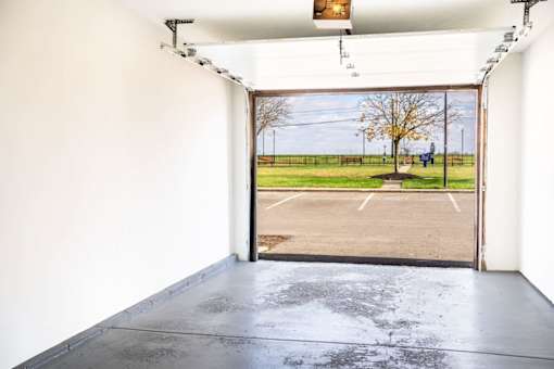 A view of an open gate leading to a parking lot.