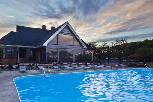 A swimming pool in front of a house.