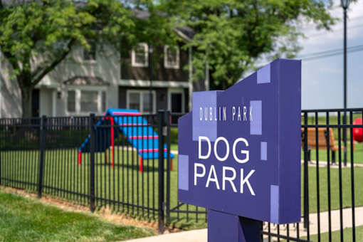 A sign that says Dublin Park Dog Park in front of a house.