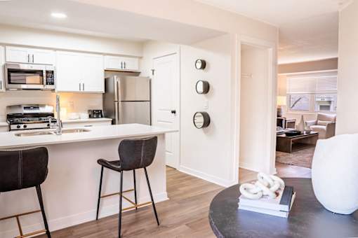 A modern kitchen with white cabinets and a black countertop.