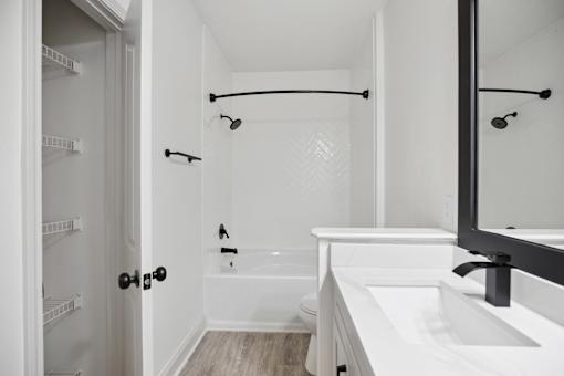 A white bathroom with a walk in shower and a white bathtub.