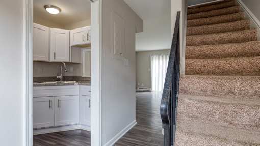 A staircase with a carpeted runner leads up to a second floor.