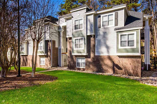 A row of houses with a green lawn in front.