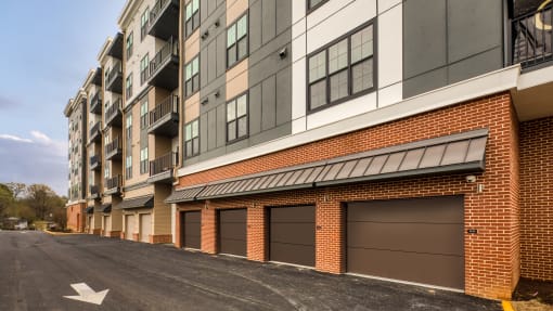a brick building with brown garage doors on a street at Aura Stonebridge, Virginia