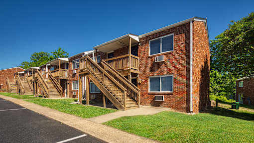 A red brick building with a wooden staircase leading to the second floor.