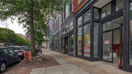 a city street with a bench and cars parked on the side of the road