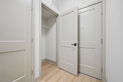 A white door is open to a small closet.