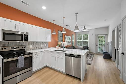 A modern kitchen with white cabinets and stainless steel appliances.