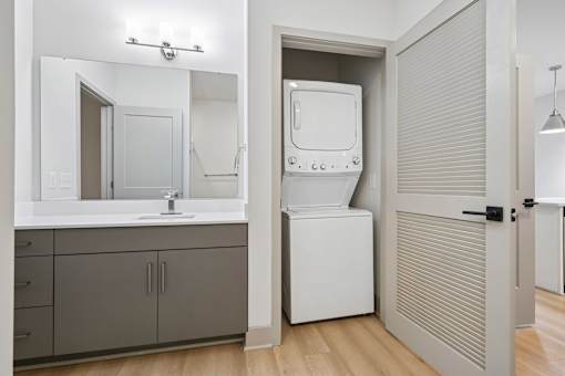 A bathroom with a white sink and a white cabinet.