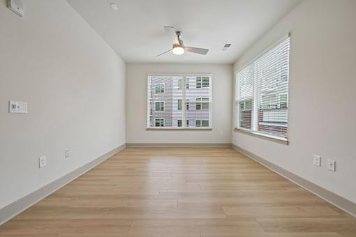 A room with a ceiling fan and a window with blinds.