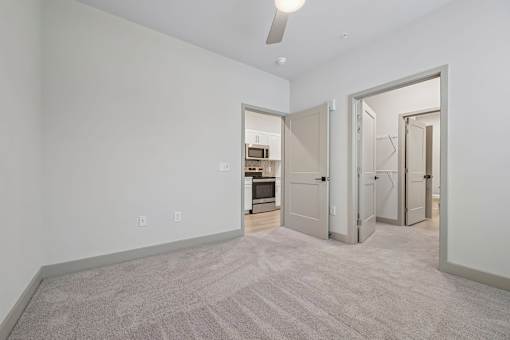 A room with a carpeted floor and a ceiling fan.