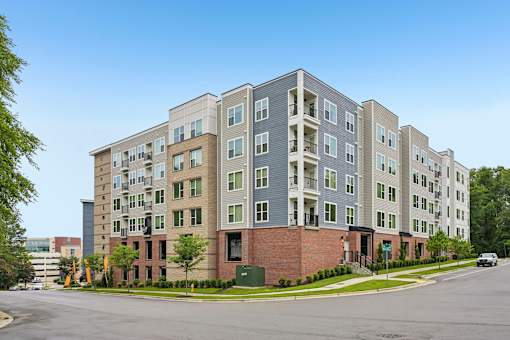 A large apartment building with a parking lot in front.