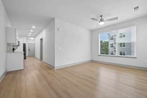 A room with a ceiling fan and a window with blinds.