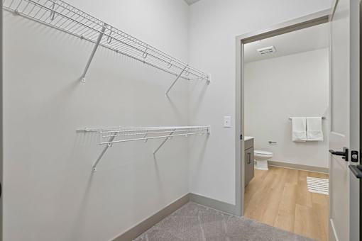 A white bathroom with a walk in shower and a towel hanging on the door.
