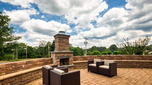 the patio has a stone fireplace and furniture on it