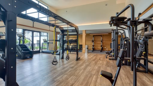 a gym with cardio equipment and weights on a wooden floor at Ainsworth, Virginia, 23228