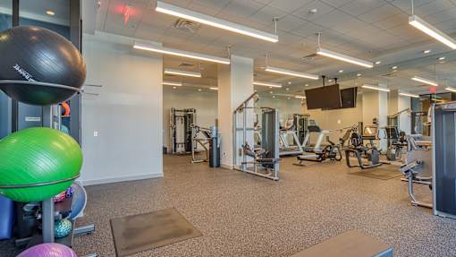 A gym with a variety of equipment including a green exercise ball.