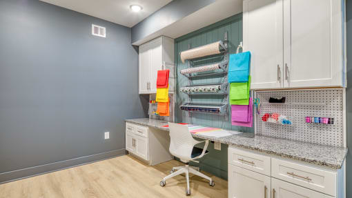 a home office with white cabinets and a desk with a chair at The Bella at Westchester, Midlothian, 23113