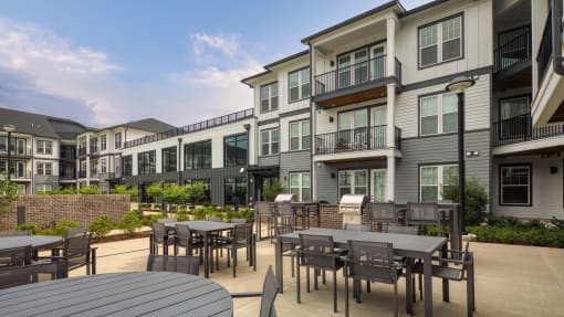 an outdoor patio with tables and chairs at an apartment complex at Ainsworth, Richmond, Virginia
