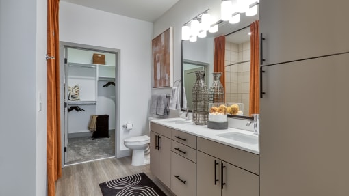 a bathroom with a large mirror and a sink and a toilet at Aura Stonebridge, Virginia