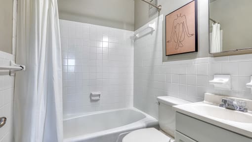 a white bathroom with a tub and a sink and a toilet