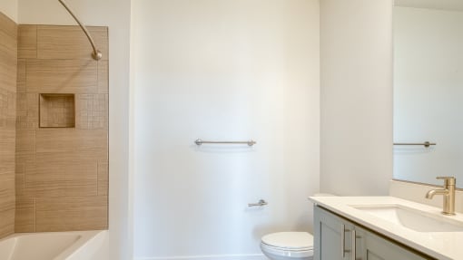 a bathroom with a sink and a toilet and a shower at The Port at East Beach Apartments and Marina, Virginia