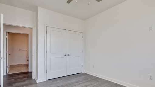 an empty bedroom with white doors and a door to a closet at The Port at East Beach Apartments and Marina, Norkfolk, VA, 23518