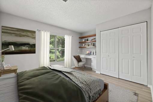 A bedroom with a bed, desk, and chair.