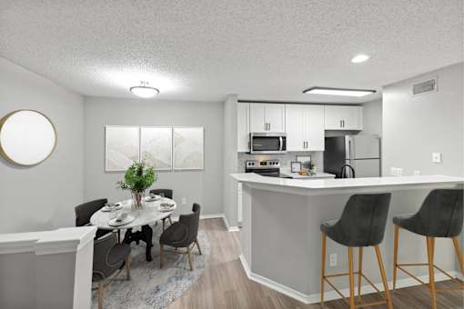 A kitchen with a dining table and chairs.