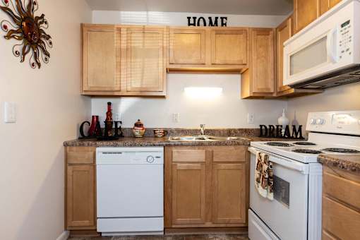 A kitchen with wooden cabinets and white appliances.