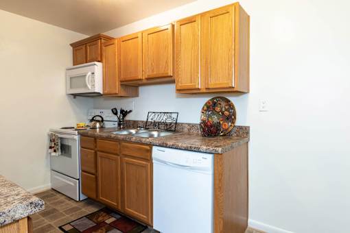 A kitchen with wooden cabinets and white appliances.