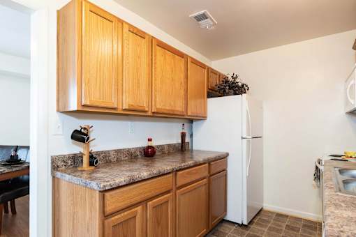 A kitchen with wooden cabinets and a white refrigerator.